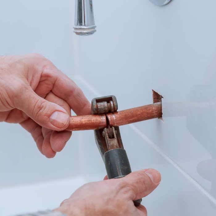 hand-of-working-cutting-copper-pipe-plumbing.jpg